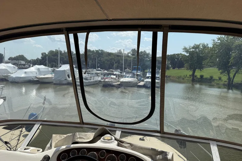 Slide: The Image of 1997 Sea Ray 370 Aft Cabin view from helm, overlooking marina with docked boats. - 23