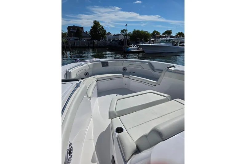 Slide: The Image of 2025 Bertram 39 CC boat interior with cushioned seating, docked at a marina. - 2