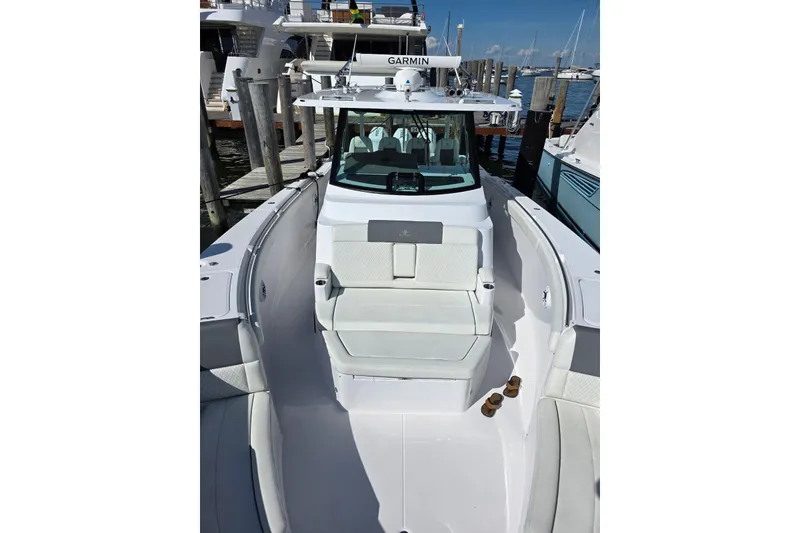 Slide: The Image of 2025 Bertram 39 CC boat docked, featuring sleek white seating and Garmin navigation system. - 0