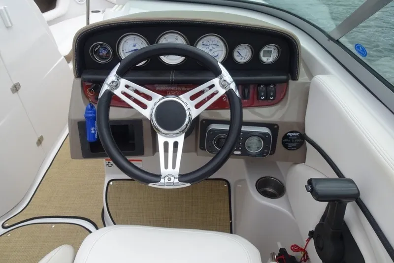 Slide: The Image of 2008 Four Winns H260 boat dashboard with steering wheel and gauges. - 16