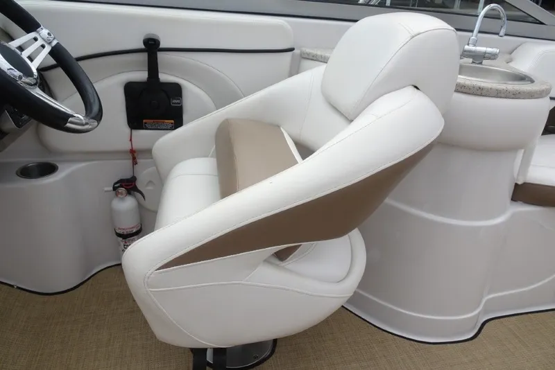 Slide: The Image of 2008 Four Winns H260 boat interior with white captain's chair and steering wheel. - 13