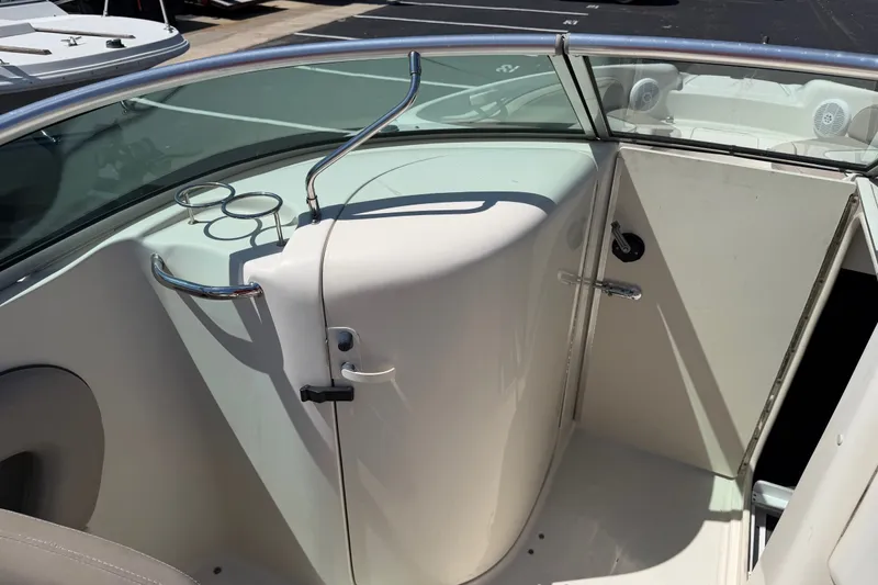 Slide: The Image of 2003 Sea Ray 240 Sundeck interior with cup holders and storage compartment. - 6