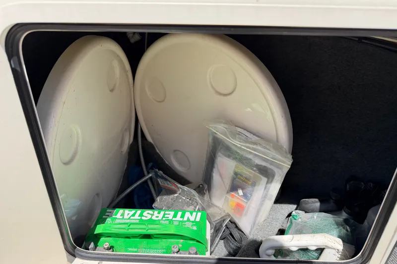 Slide: The Image of Storage compartment of 2003 Sea Ray 240 Sundeck with battery and accessories. - 8