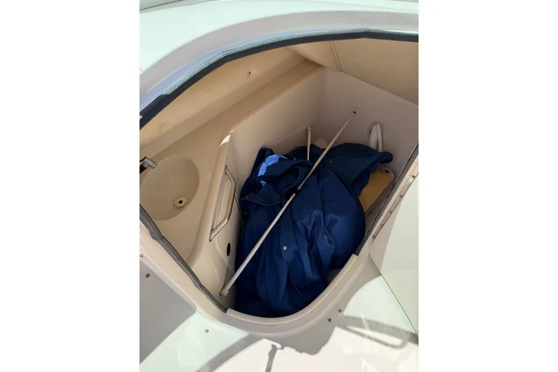 Slide: The Image of Storage compartment of 2003 Sea Ray 240 Sundeck boat with blue cover and poles. - 18