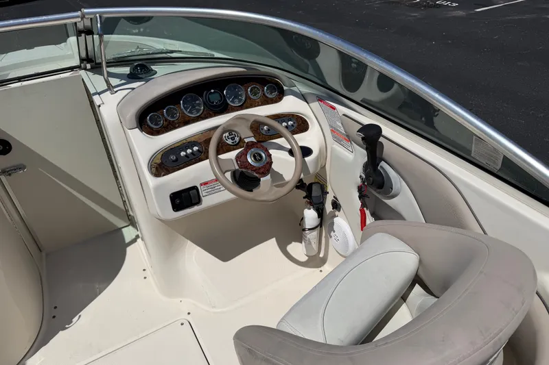 Slide: The Image of 2003 Sea Ray 240 Sundeck boat cockpit with steering wheel and control panel. - 7