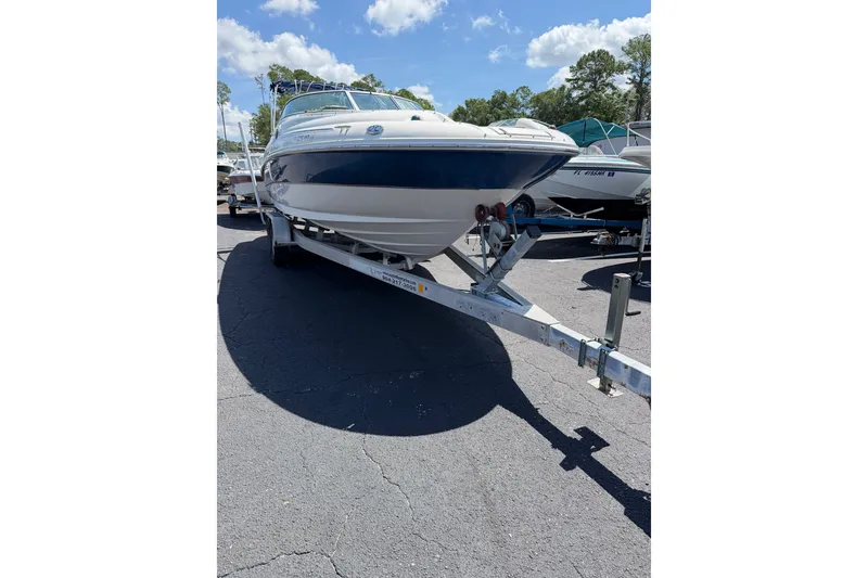 Slide: The Image of 2003 Sea Ray 240 Sundeck boat on trailer under clear blue sky. - 16