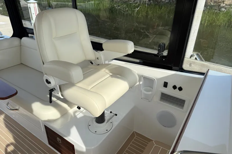 Slide: The Image of Captain's chair in 2024 MJM Yachts MJM 3, featuring luxurious white upholstery and modern controls. - 32