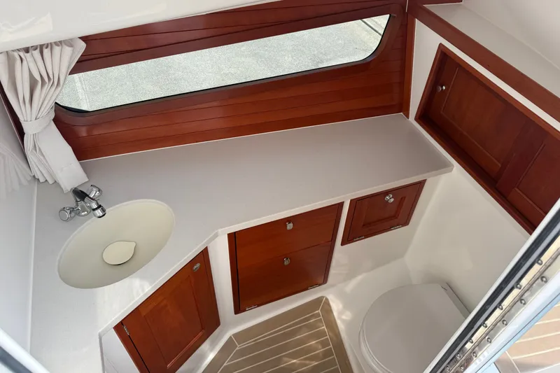 Slide: The Image of 2024 MJM 3 yacht bathroom with wooden cabinets, sink, and window. - 37