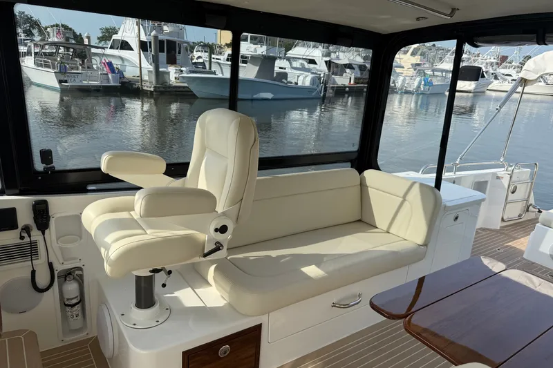 Slide: The Image of 2024 MJM Yachts MJM 3 interior with cream seating and marina view. - 21