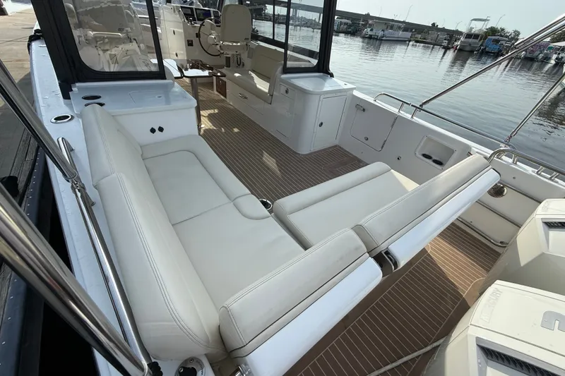 Slide: The Image of 2024 MJM Yachts MJM 3 interior with white seating and wood flooring by the water. - 14