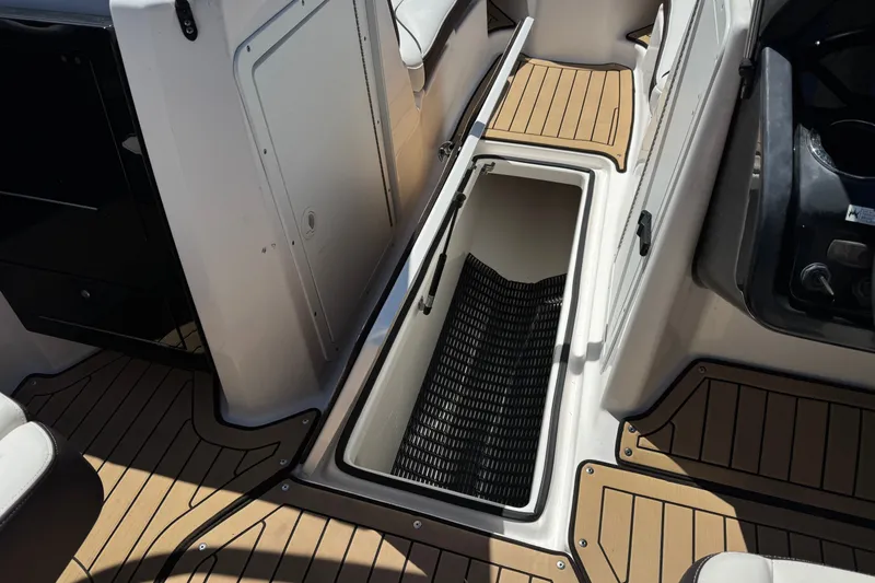Slide: The Image of 2022 Yamaha Boats 212S interior storage compartment with teak-style flooring. - 22
