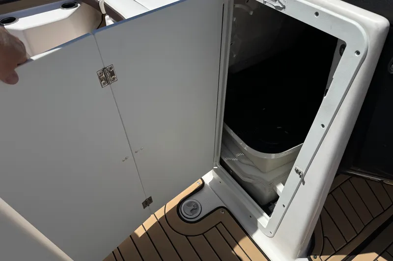 Slide: The Image of Open storage compartment on 2022 Yamaha Boats 212S, featuring sleek design and wood-textured flooring. - 28