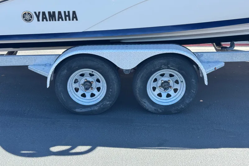 Slide: The Image of Trailer wheels of a 2022 Yamaha Boats 212S on pavement. - 29