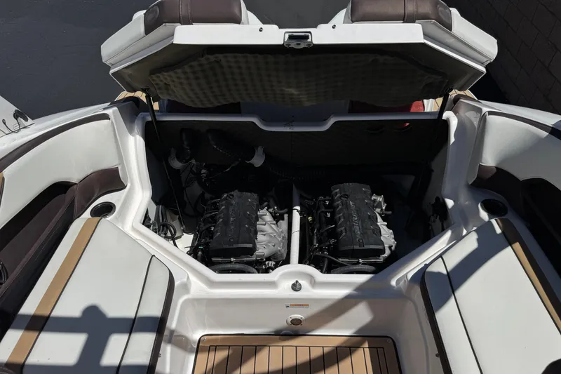 Slide: The Image of 2022 Yamaha Boats 212S engine compartment with dual engines, open hatch, and seating area. - 18