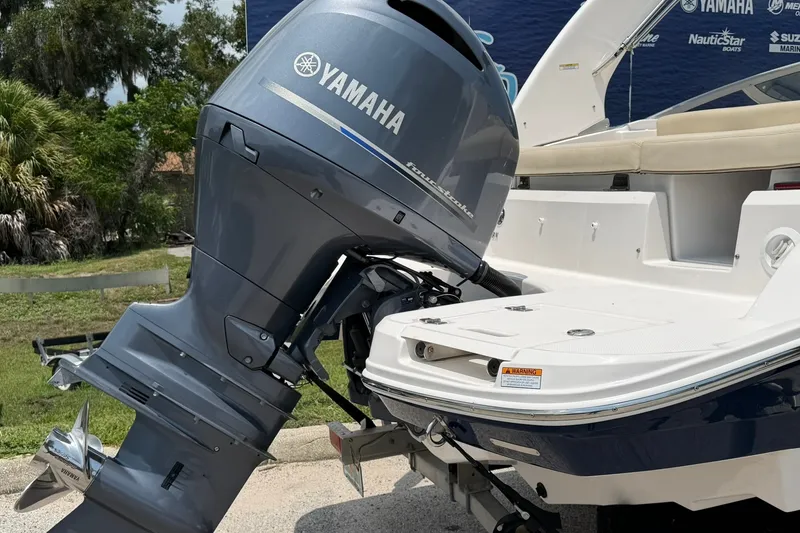 Slide: The Image of 2018 Regal 2100 boat with Yamaha outboard motor, parked outdoors. - 16