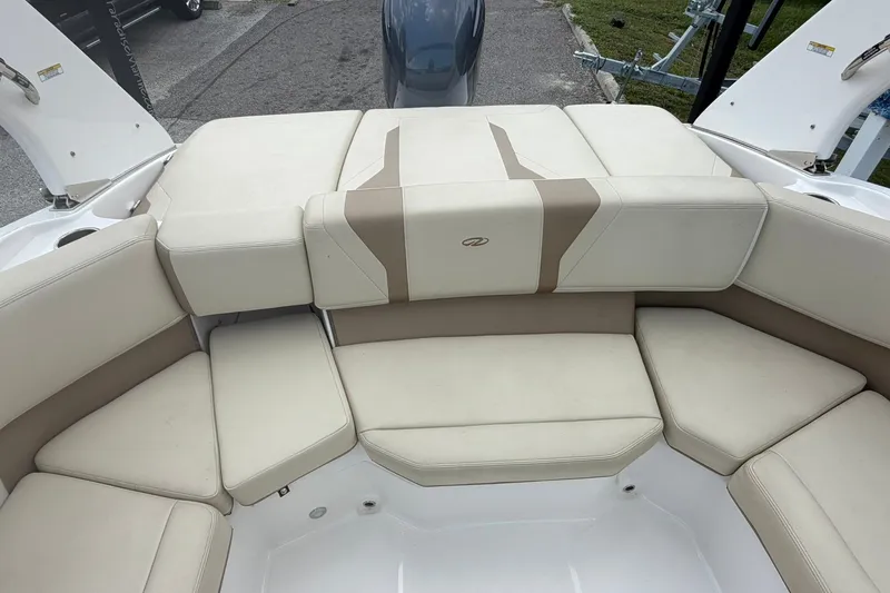 Slide: The Image of 2018 Regal 2100 boat interior with beige cushioned seating arrangement. - 11