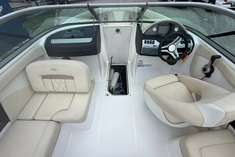 Slide: The Image of Interior of a 2018 Regal 2100 boat with beige seating and steering console. - 7