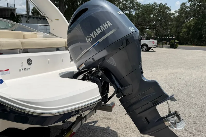 Slide: The Image of 2018 Regal 2100 boat with Yamaha outboard motor in a parking area. - 18
