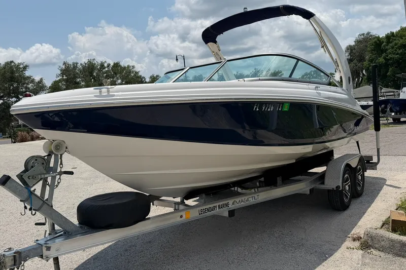 Slide: The Image of 2018 Regal 2100 boat on trailer, parked outdoors under cloudy sky. - 20