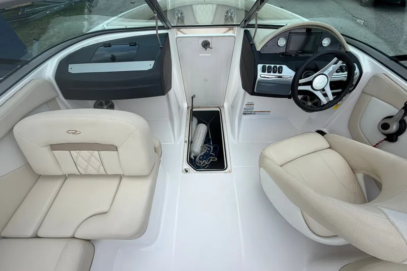 Slide: The Image of Interior of a 2018 Regal 2100 boat with beige seating and modern dashboard. - 4
