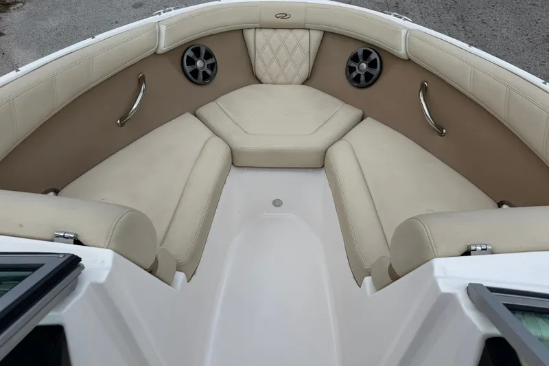 Slide: The Image of 2018 Regal 2100 boat interior with beige seating and stainless steel accents. - 2