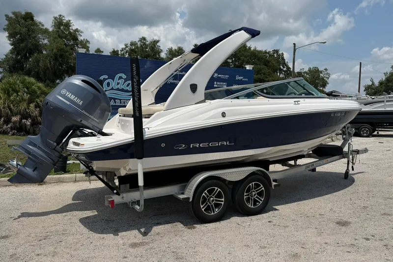 Slide: The Image of 2018 Regal 2100 boat with Yamaha engine on trailer, parked outdoors. - 15