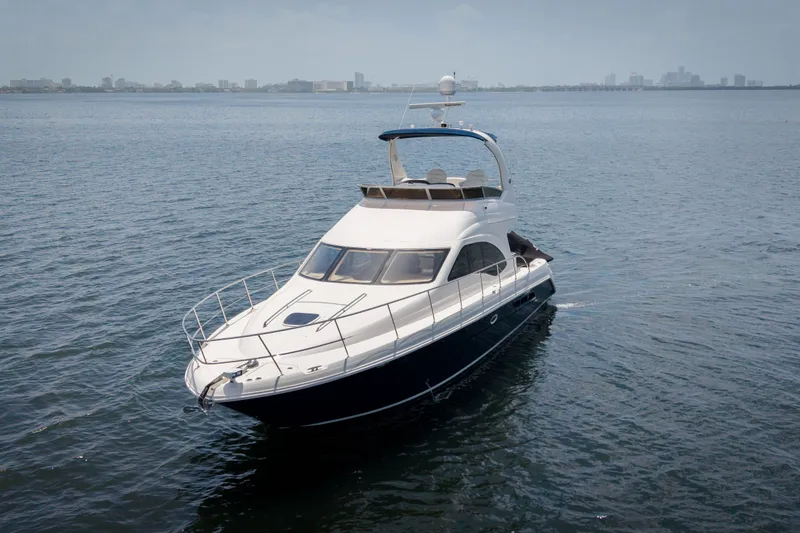 Slide: The Image of 2006 Sea Ray 44 Sedan Bridge yacht cruising on open water. - 2