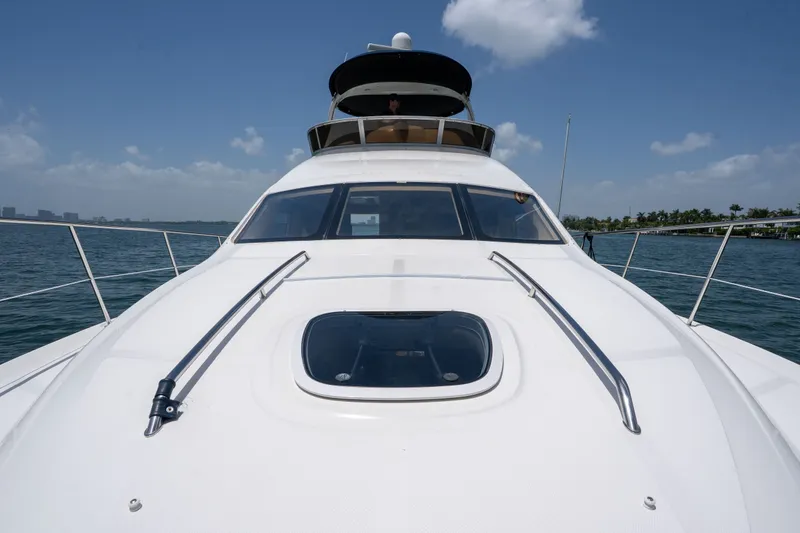 Slide: The Image of 2006 Sea Ray 44 Sedan Bridge yacht on open water under clear blue sky. - 15