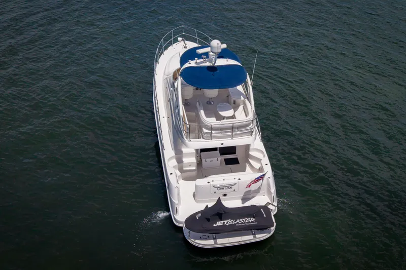 Slide: The Image of 2006 Sea Ray 44 Sedan Bridge yacht with blue canopy on open water. - 6