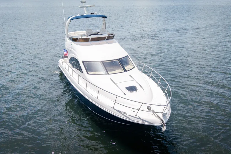 Slide: The Image of 2006 Sea Ray 44 Sedan Bridge yacht cruising on open water. - 3