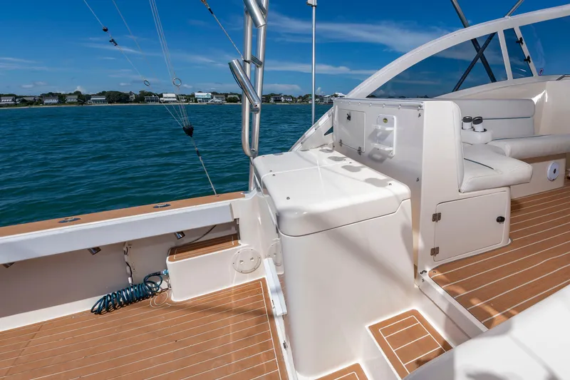Slide: The Image of The image shows the deck of a 2004 Albemarle 410 Express Fisherman. It features wood flooring and white seating. - 18