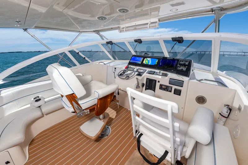 Slide: The Image of The image shows the cockpit of a 2004 Albemarle 410 Express Fisherman. It features a captain's chair, modern dashboard, and a view of the water. - 21