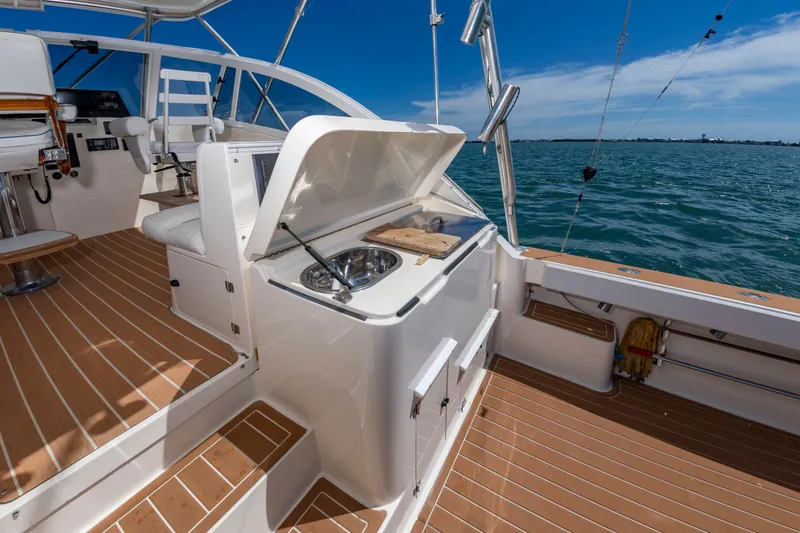 Slide: The Image of The image shows the deck of a 2004 Albemarle 410 Express Fisherman with a sink and cutting board. - 16