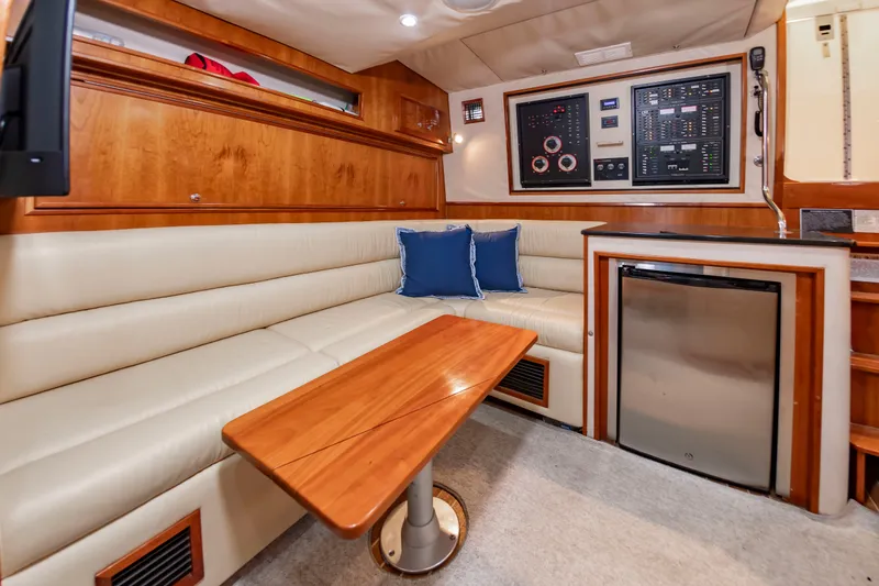 Slide: The Image of Interior of a 2004 Albemarle 410 Express Fisherman with beige sofa and wooden table. - 34