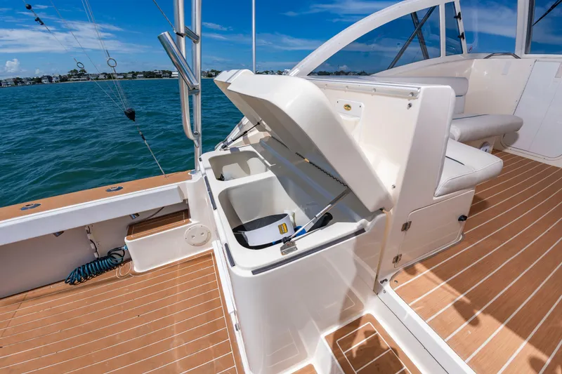 Slide: The Image of The image shows the deck of a 2004 Albemarle 410 Express Fisherman with storage and seating area. - 19