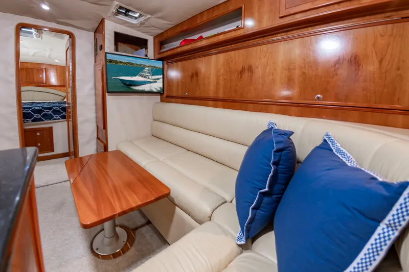 Slide: The Image of Interior of a 2004 Albemarle 410 Express Fisherman with beige sofa and wooden table. - 37