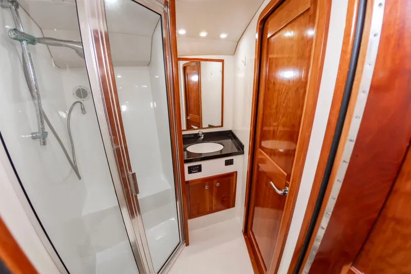 Slide: The Image of The image shows a sleek bathroom with wooden doors, a shower, and a sink with a mirror. - 40