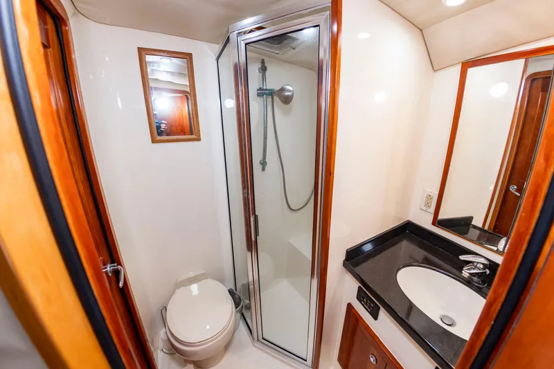Slide: The Image of The image shows a boat bathroom with a shower, sink, and toilet. - 41