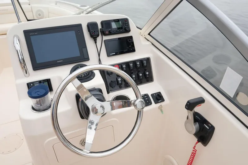 Slide: The Image of Manufacturer Provided Image: 2022 Grady-White Freedom 215 boat dashboard with steering wheel and electronic controls. - 23