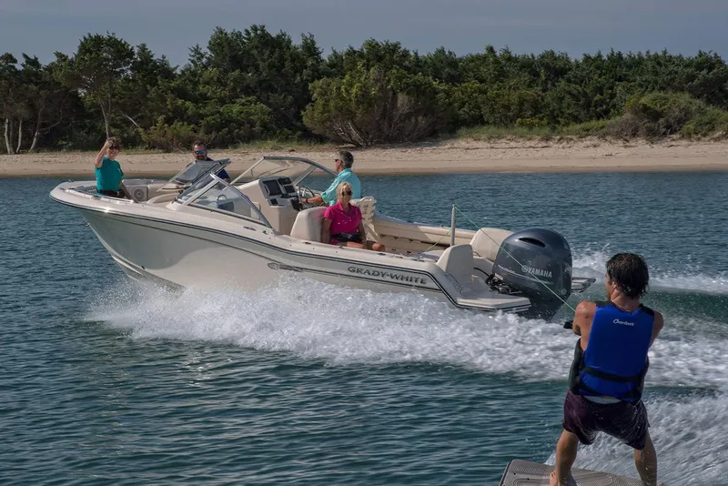 Slide: The Image of Manufacturer Provided Image: 2022 Grady-White Freedom 215 boat towing a wakeboarder near a sandy shore. - 17