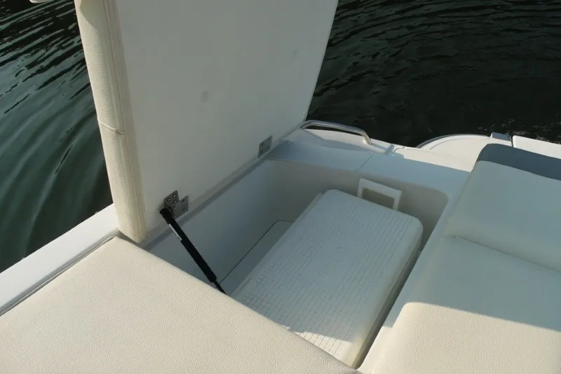 Slide: The Image of Open storage compartment on 2020 Cobalt 220S boat with cushioned seating. - 11