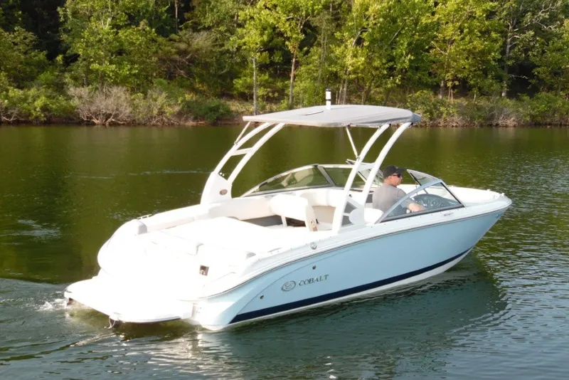 Slide: The Image of 2020 Cobalt 220S boat cruising on a serene lake surrounded by lush greenery. - 5