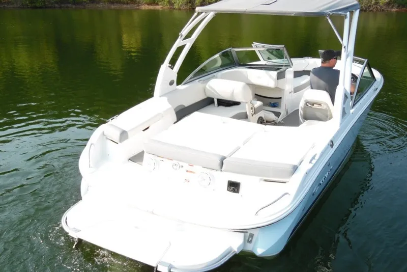 Slide: The Image of 2020 Cobalt 220S boat cruising on a calm lake with a canopy. - 8