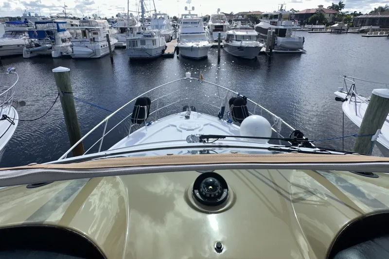 Slide: The Image of 2003 Carver 466 Motor Yacht docked at marina, surrounded by other boats. - 57