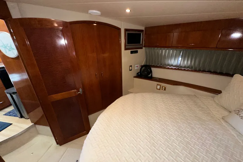 Slide: The Image of Luxurious 2003 Carver 466 Motor Yacht bedroom with wood cabinetry and cozy bedding. - 16