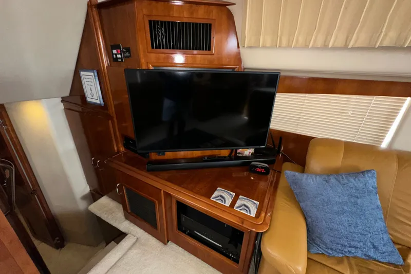 Slide: The Image of Interior of 2003 Carver 466 Motor Yacht with TV, wooden cabinetry, and beige seating. - 35