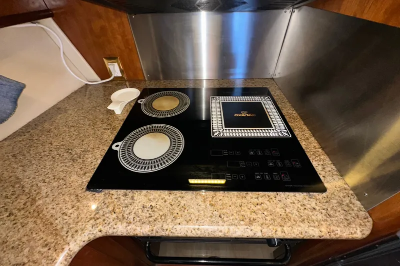 Slide: The Image of Granite countertop with electric cooktop in 2003 Carver 466 Motor Yacht kitchen. - 23