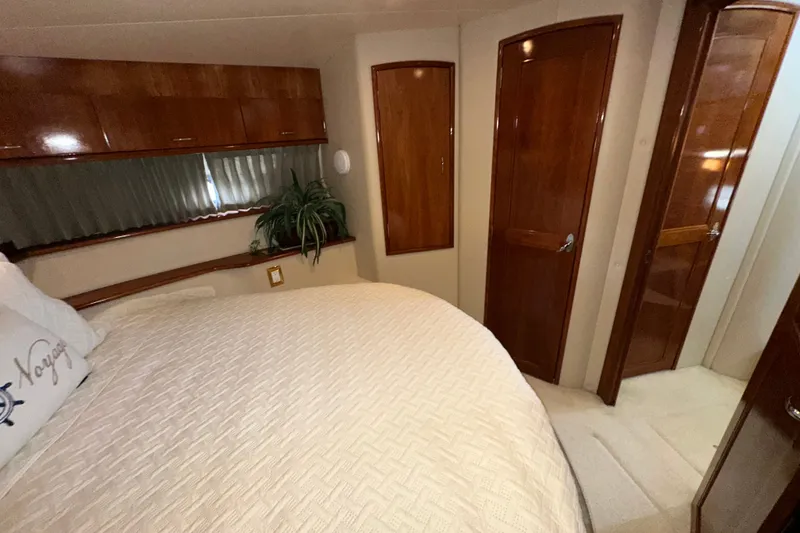 Slide: The Image of Luxurious bedroom interior of 2003 Carver 466 Motor Yacht with wood accents and cozy bedding. - 17