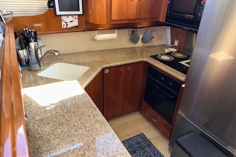 Slide: The Image of Luxurious kitchen in 2003 Carver 466 Motor Yacht with modern appliances and granite countertops. - 27