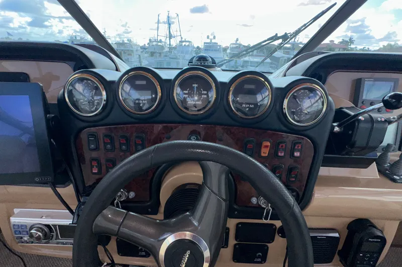 Slide: The Image of 2003 Carver 466 Motor Yacht helm with gauges, steering wheel, and control panel. - 60